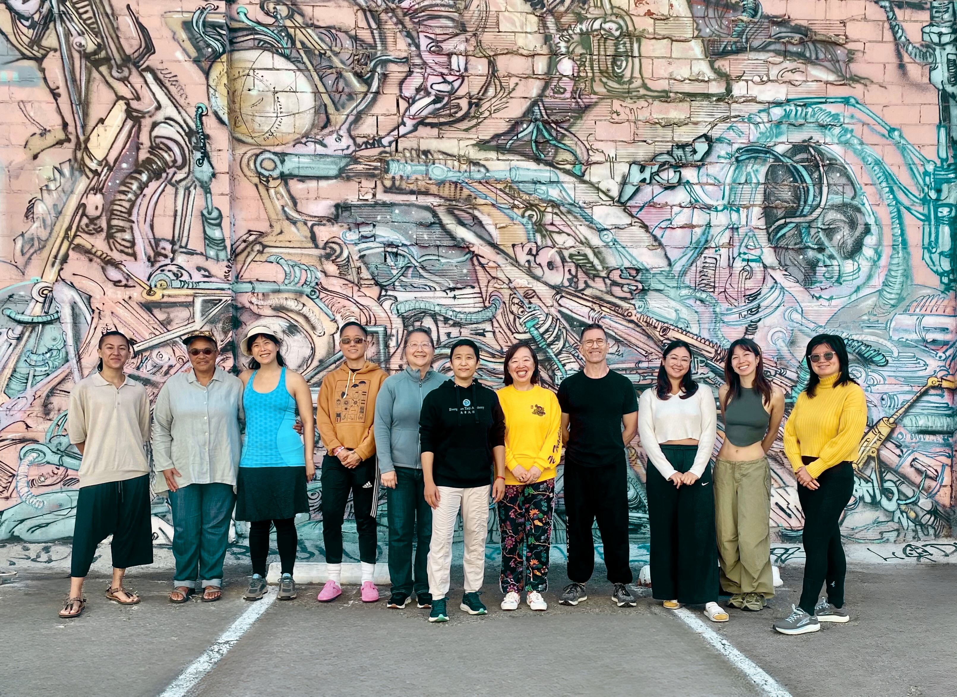 Group photo for Qigong at Oakland Test Kitchen in front of wall mural